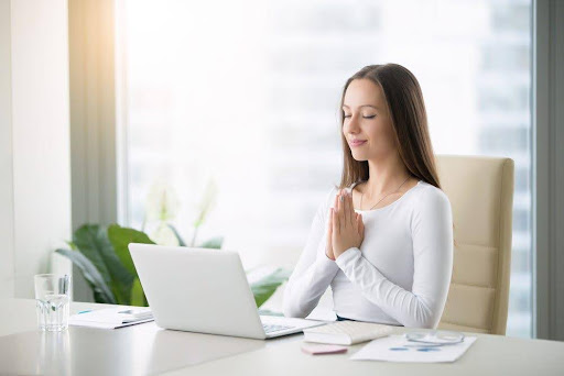 a person meditating in front of a computer